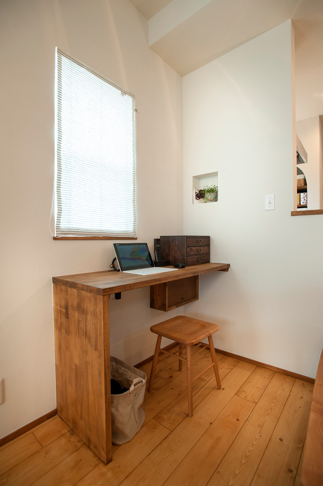 Идея дизайна: кабинет в восточном стиле с белыми стенами, паркетным полом среднего тона, встроенным рабочим столом и коричневым полом