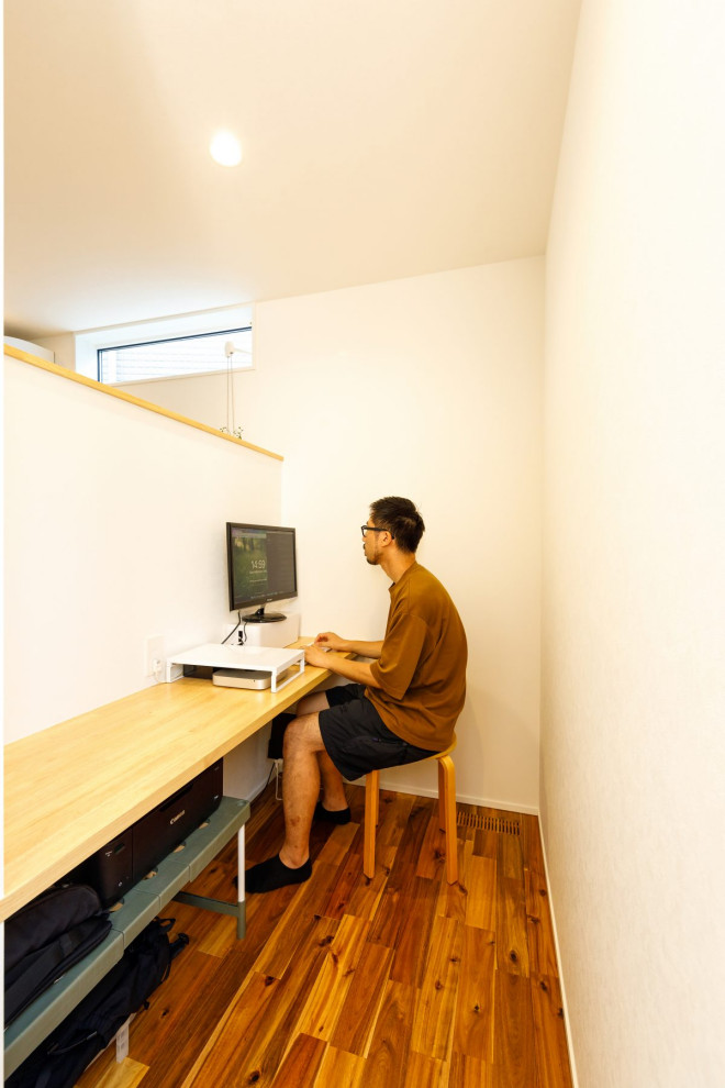 Mittelgroßes Industrial Arbeitszimmer mit Arbeitsplatz, weißer Wandfarbe, braunem Holzboden, Einbau-Schreibtisch, braunem Boden, Tapetendecke und Tapetenwänden in Tokio Peripherie