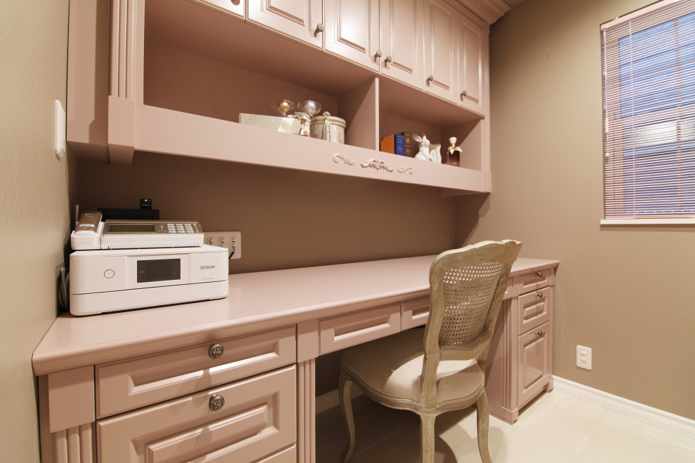 На фото: рабочее место среднего размера в современном стиле с розовыми стенами, мраморным полом, встроенным рабочим столом, бежевым полом, потолком с обоями и обоями на стенах без камина с