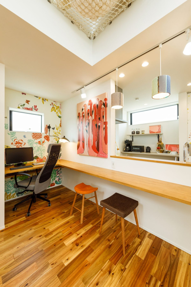 Diseño de despacho industrial de tamaño medio con paredes multicolor, suelo de madera en tonos medios, escritorio empotrado, suelo marrón, papel pintado y papel pintado