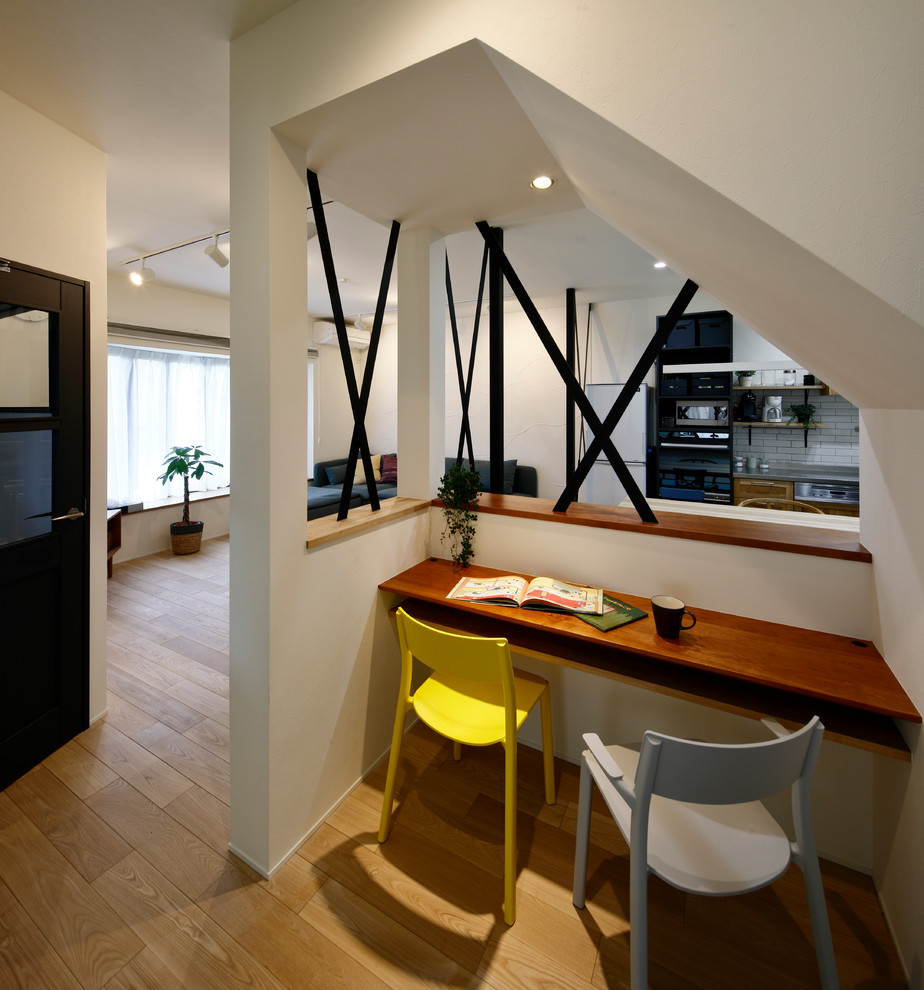 Idée de décoration pour un petit bureau nordique avec un mur blanc, un sol en bois brun, un bureau intégré et un sol marron.