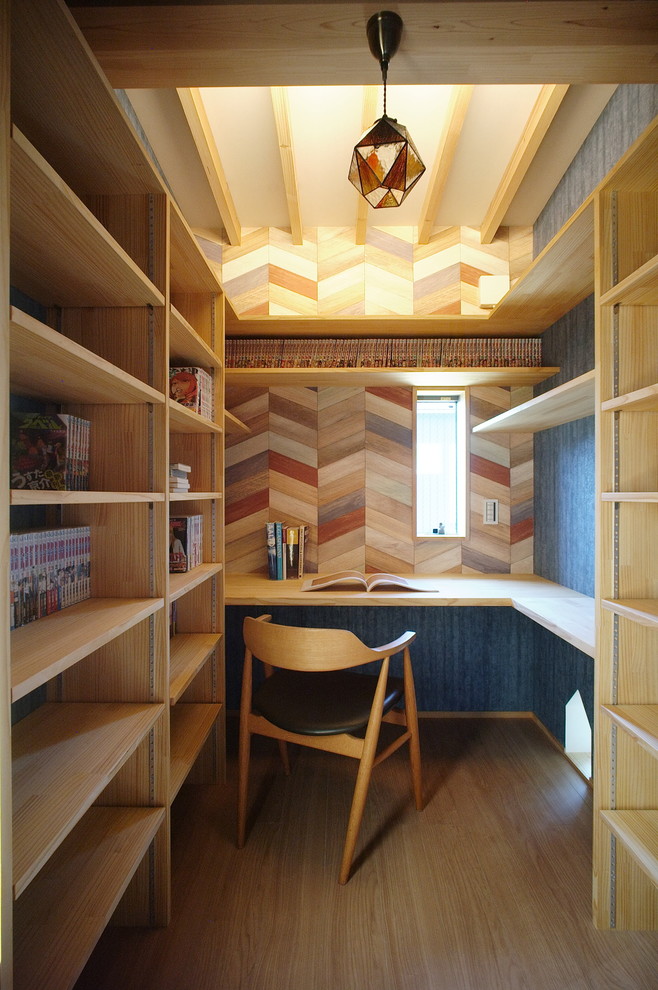 Kleines Modernes Arbeitszimmer mit hellem Holzboden, Einbau-Schreibtisch, blauer Wandfarbe und beigem Boden in Sonstige
