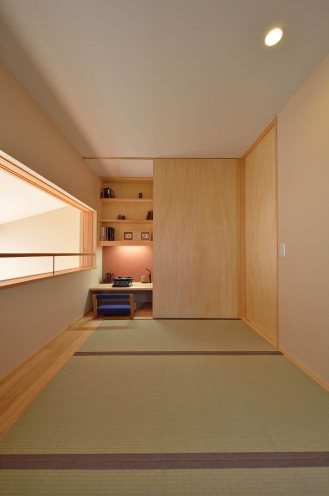 他の地域にあるアジアンスタイルのおしゃれなホームオフィス・書斎 (ベージュの壁、畳、造り付け机、緑の床) の写真