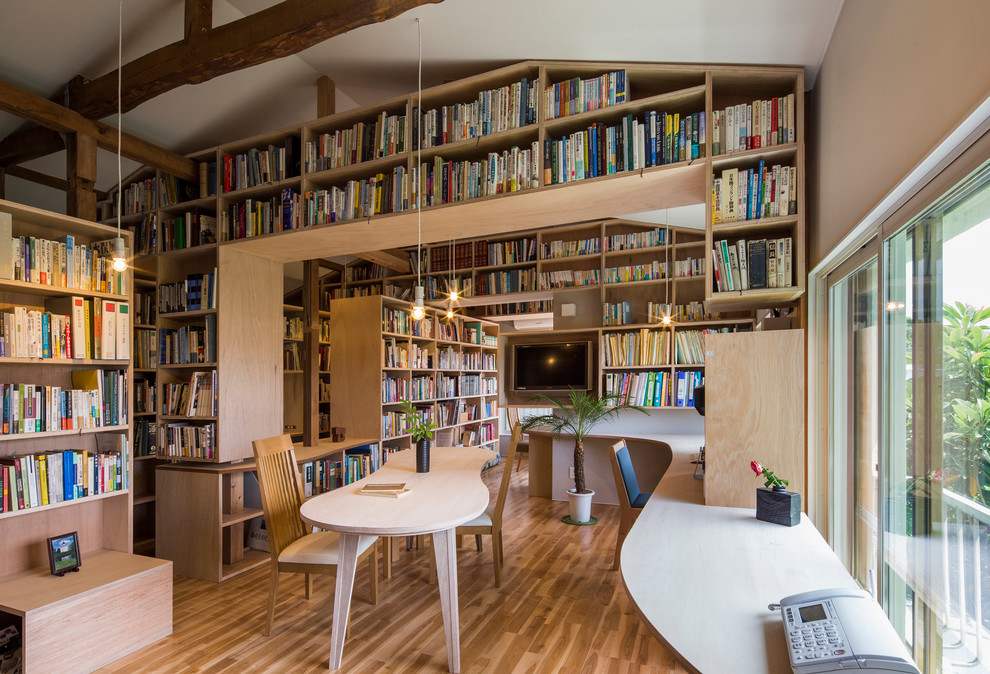 Источник вдохновения для домашнего уюта: домашняя библиотека в современном стиле с белыми стенами, паркетным полом среднего тона и встроенным рабочим столом