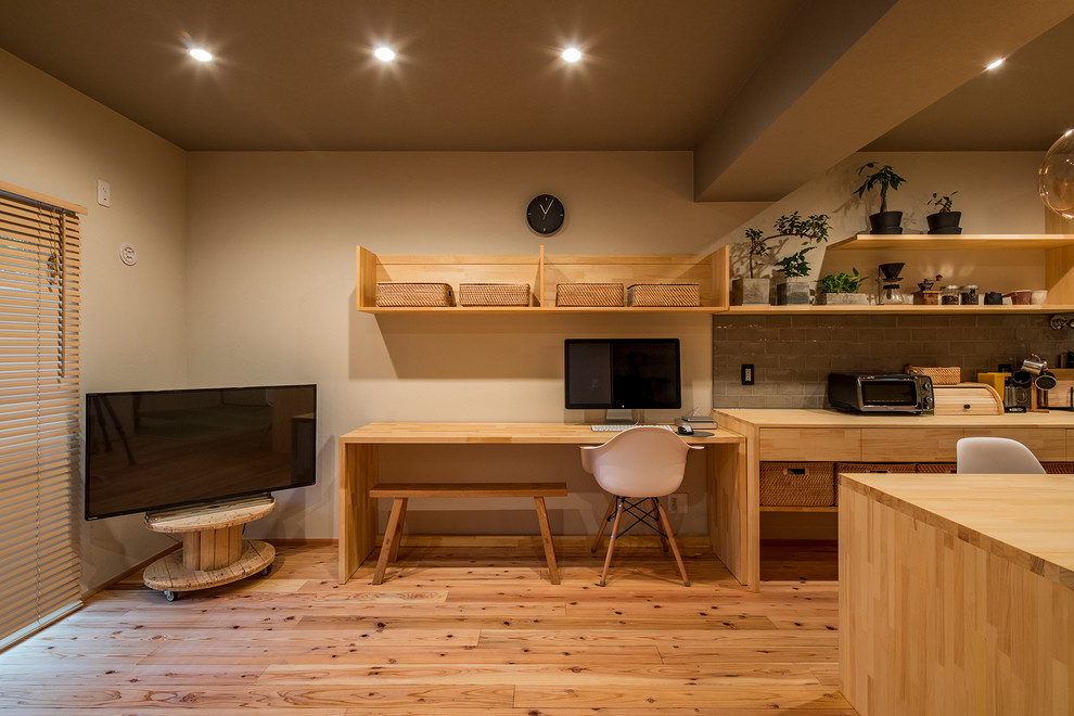 東京23区にあるアジアンスタイルのおしゃれなホームオフィス・書斎 (ベージュの壁、無垢フローリング、自立型机、茶色い床) の写真
