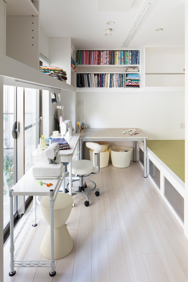 Inspiration för ett litet funkis hemmastudio, med vita väggar, plywoodgolv, ett fristående skrivbord och vitt golv