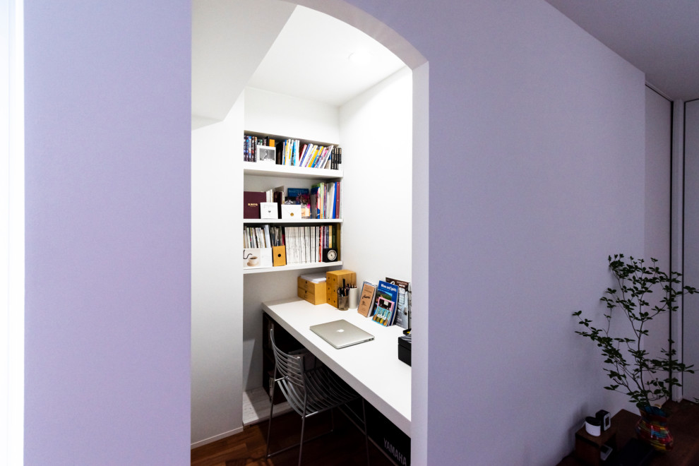 Esempio di un piccolo ufficio moderno con pareti bianche, pavimento in legno verniciato, nessun camino, scrivania incassata e pavimento marrone