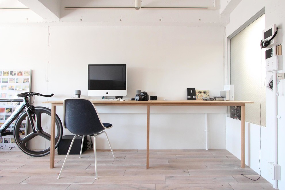 Стильный дизайн: кабинет в скандинавском стиле с белыми стенами, деревянным полом, отдельно стоящим рабочим столом и бежевым полом - последний тренд