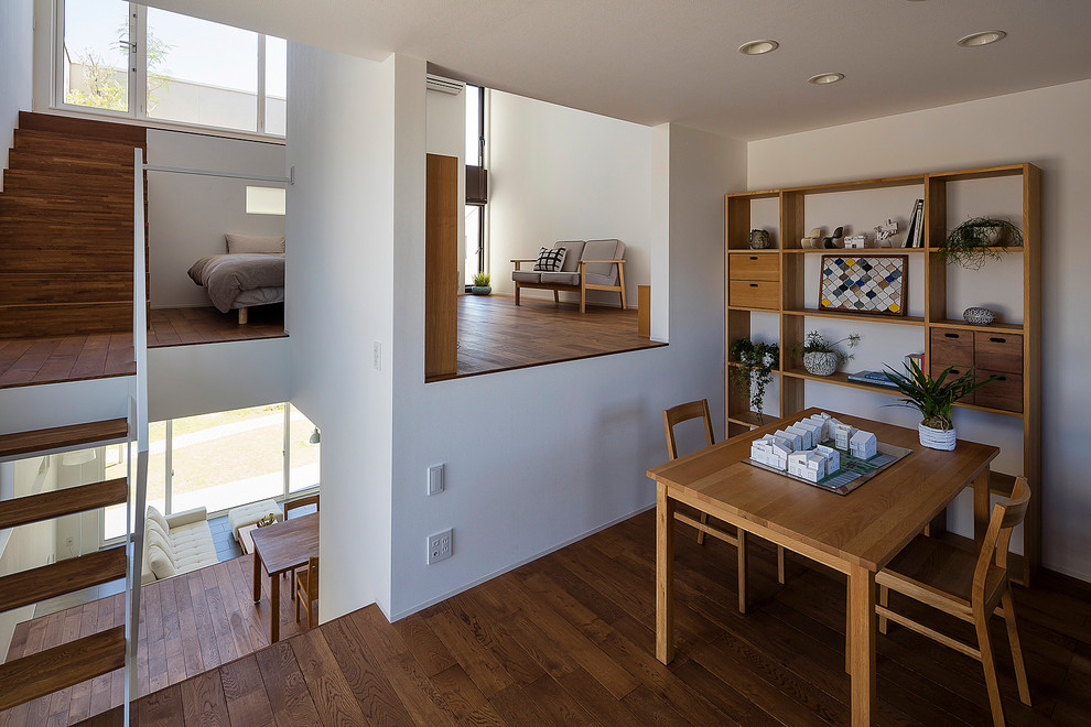 Foto di uno studio moderno con pareti bianche, pavimento in legno massello medio, scrivania autoportante e pavimento marrone
