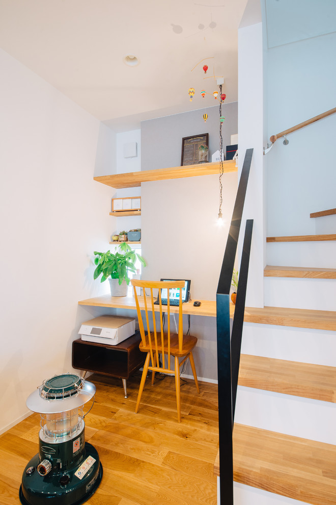 Источник вдохновения для домашнего уюта: кабинет в скандинавском стиле с серыми стенами, паркетным полом среднего тона, встроенным рабочим столом и коричневым полом без камина