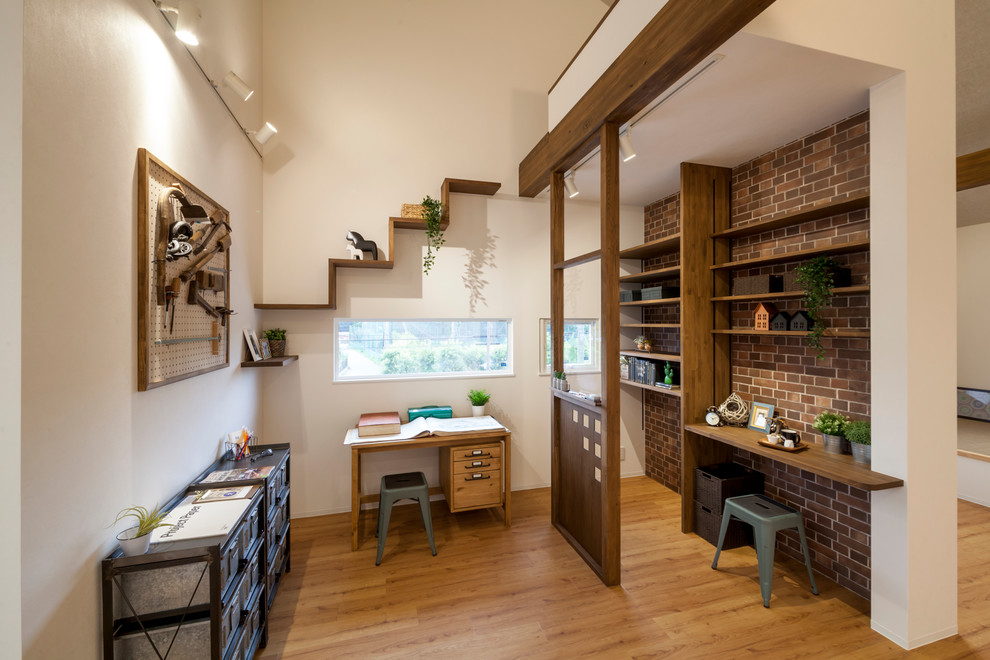 Ejemplo de despacho industrial con paredes multicolor, suelo de madera en tonos medios, escritorio independiente y suelo marrón