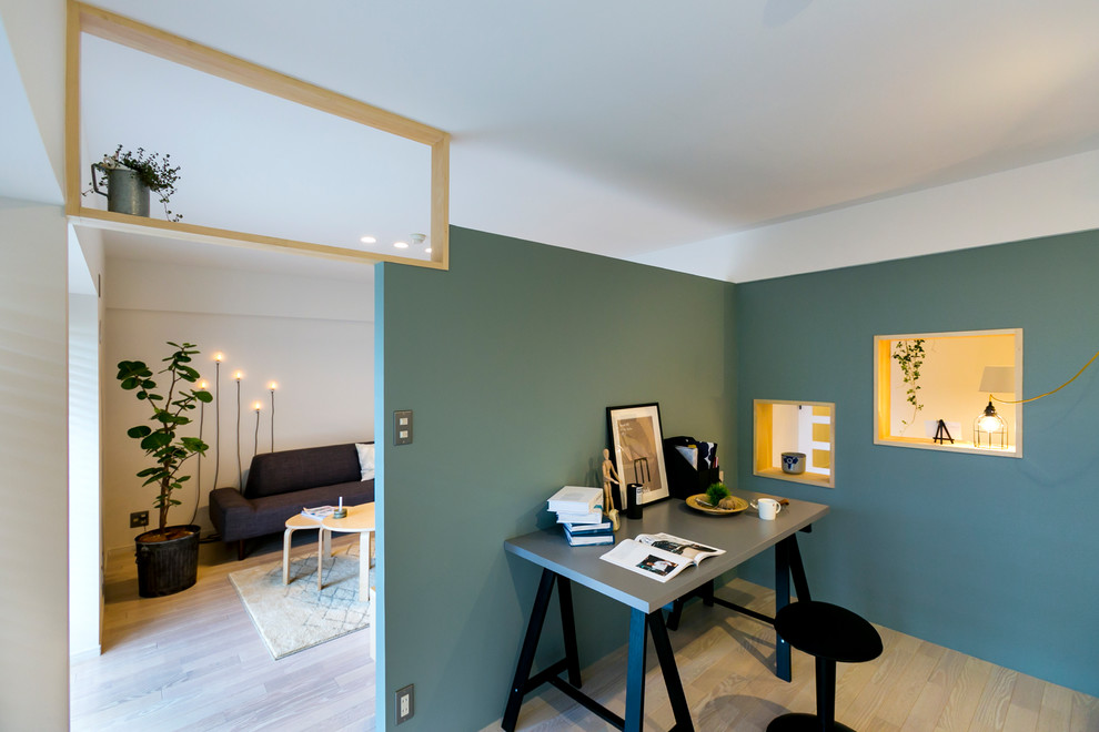 На фото: кабинет в скандинавском стиле с синими стенами, деревянным полом, отдельно стоящим рабочим столом и бежевым полом