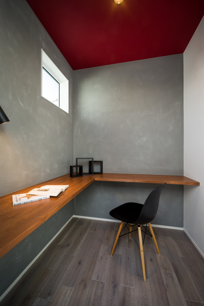 Esempio di uno studio minimalista con pareti grigie, pavimento in legno verniciato, scrivania incassata e pavimento grigio