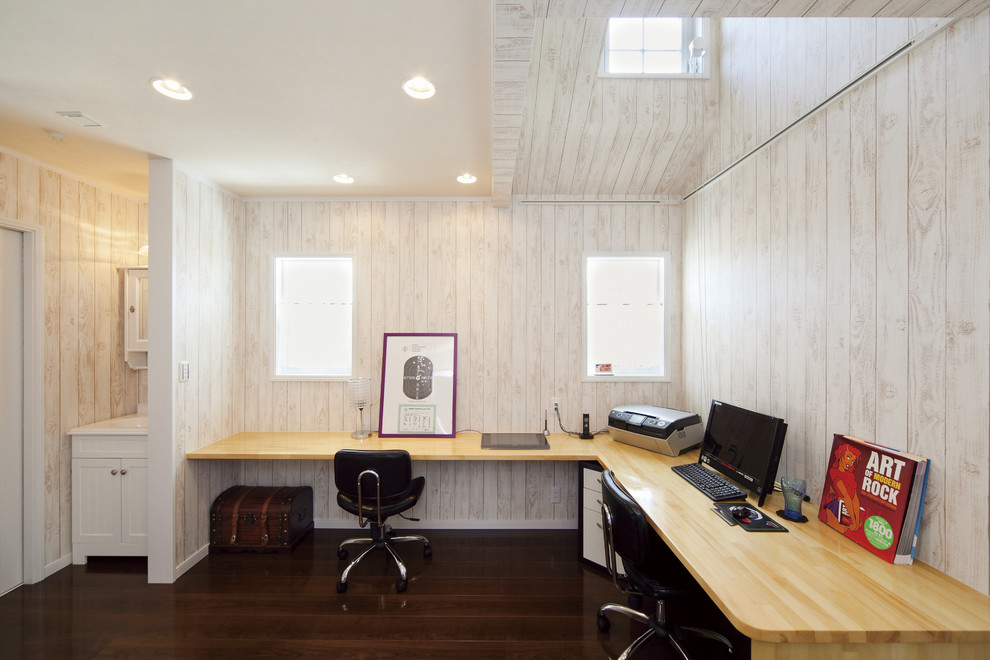 Exempel på ett asiatiskt arbetsrum, med beige väggar, mörkt trägolv, ett inbyggt skrivbord och brunt golv