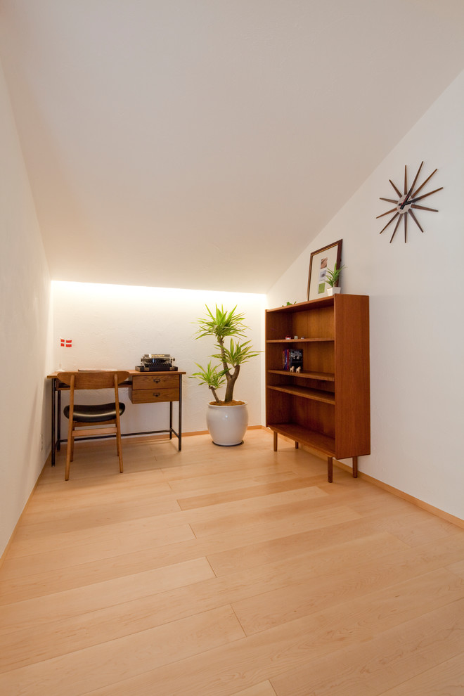 Foto de sala de manualidades escandinava grande con paredes blancas, suelo de madera clara y escritorio independiente