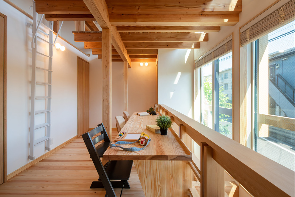Nordisches Arbeitszimmer mit weißer Wandfarbe, hellem Holzboden, Einbau-Schreibtisch und braunem Boden in Tokio