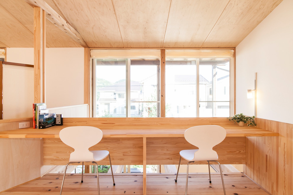 Esempio di un piccolo studio nordico con pareti bianche, scrivania incassata e pavimento in legno massello medio