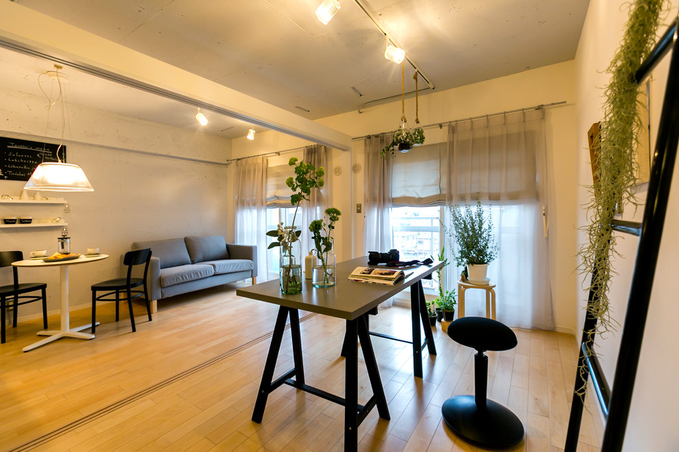 На фото: кабинет в скандинавском стиле с разноцветными стенами, светлым паркетным полом, отдельно стоящим рабочим столом и коричневым полом с