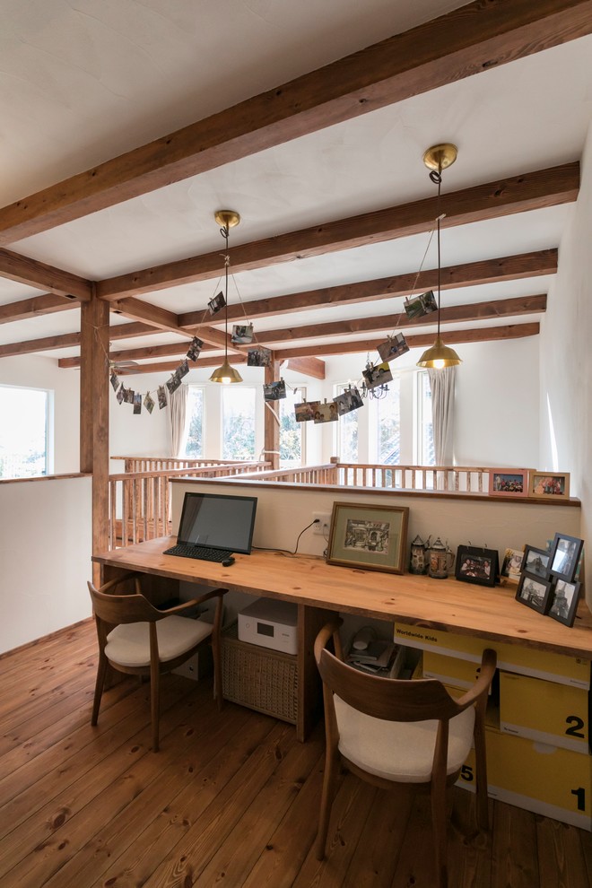 Foto di un ufficio etnico con pareti bianche, scrivania incassata, pavimento marrone e pavimento in legno massello medio