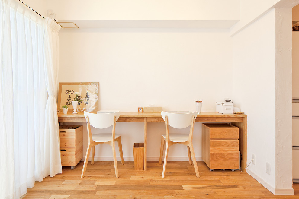東京都下にある北欧スタイルのおしゃれなホームオフィス・書斎 (造り付け机、白い壁、無垢フローリング、茶色い床) の写真