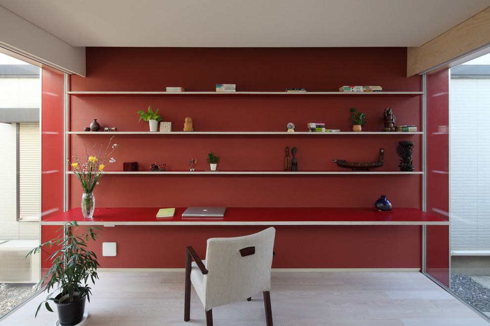 Ejemplo de despacho nórdico con paredes rojas, suelo de madera pintada, escritorio empotrado y suelo beige