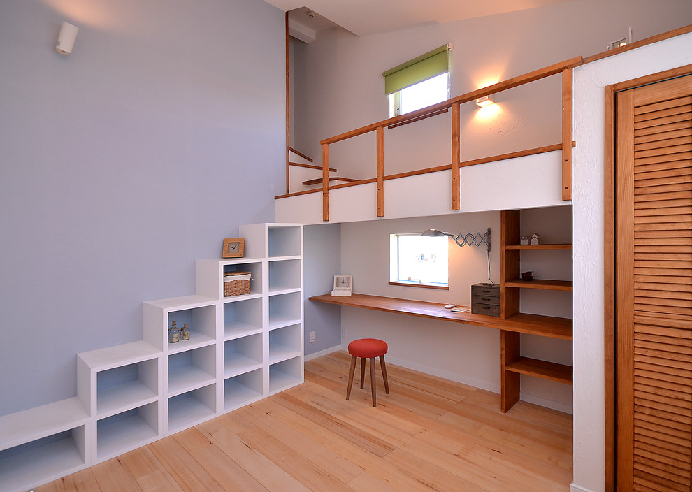 他の地域にあるコンテンポラリースタイルのおしゃれなホームオフィス・書斎 (青い壁、淡色無垢フローリング、造り付け机、茶色い床) の写真