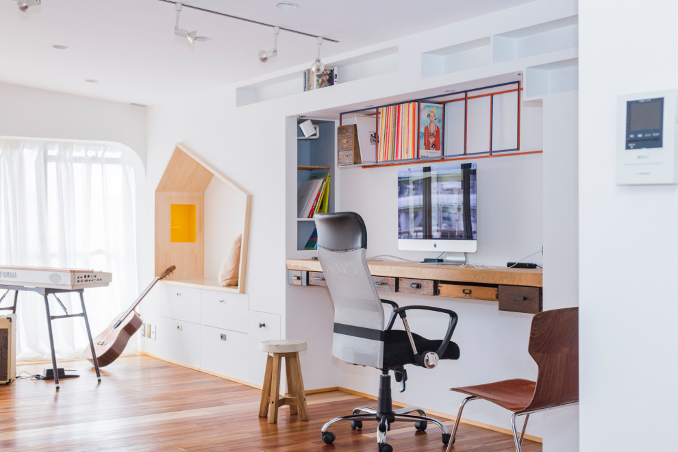 Inspiration pour un bureau design de taille moyenne avec un mur blanc, un sol en bois brun, aucune cheminée et un bureau intégré.