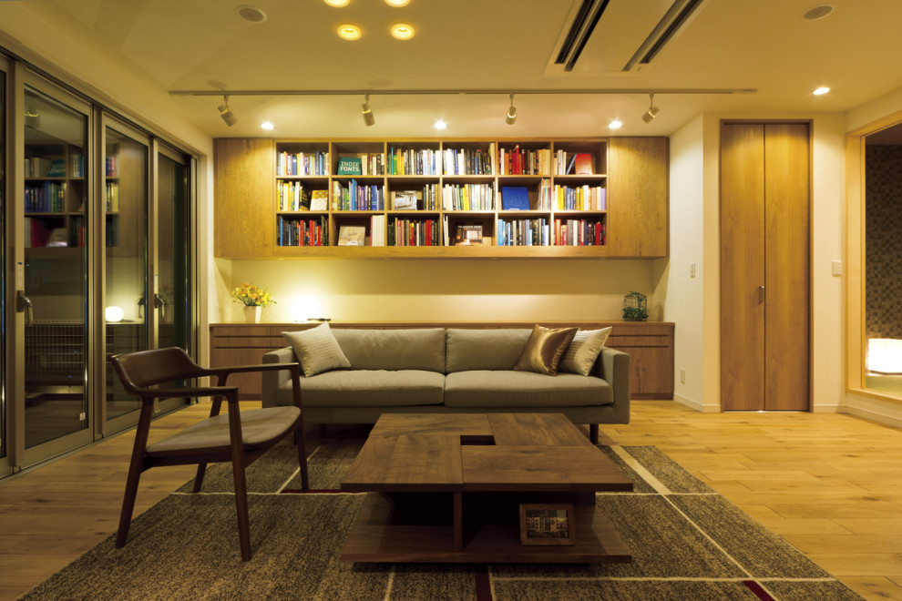 Imagen de despacho escandinavo de tamaño medio con biblioteca, paredes blancas, suelo de madera clara, suelo marrón, papel pintado y papel pintado