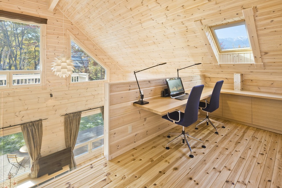 Imagen de despacho rústico grande sin chimenea con suelo de madera clara, escritorio empotrado y paredes beige