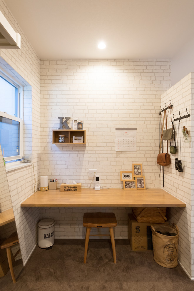 Foto di uno studio nordico con pareti bianche, scrivania incassata e pavimento marrone