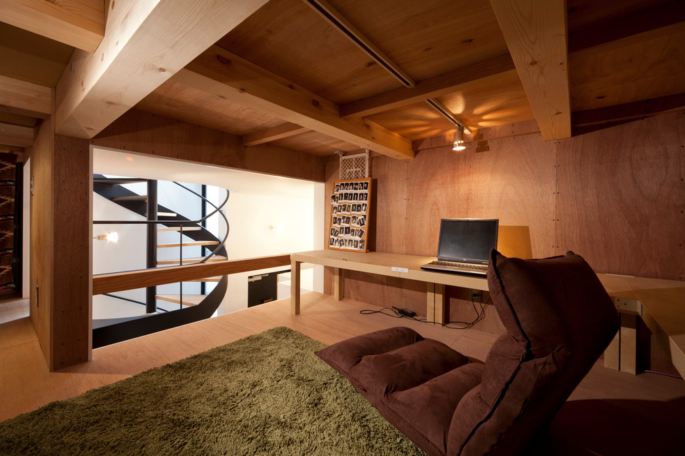 Diseño de despacho asiático sin chimenea con paredes marrones, suelo de madera clara, escritorio empotrado y suelo marrón