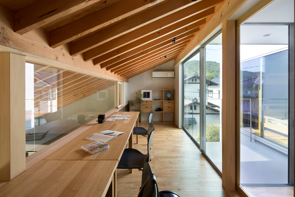 Imagen de despacho contemporáneo con paredes marrones y suelo de madera en tonos medios