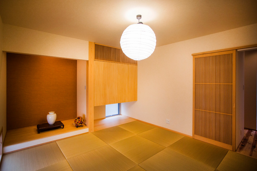 Diseño de despacho de estilo zen de tamaño medio sin chimenea con paredes blancas, tatami y suelo verde