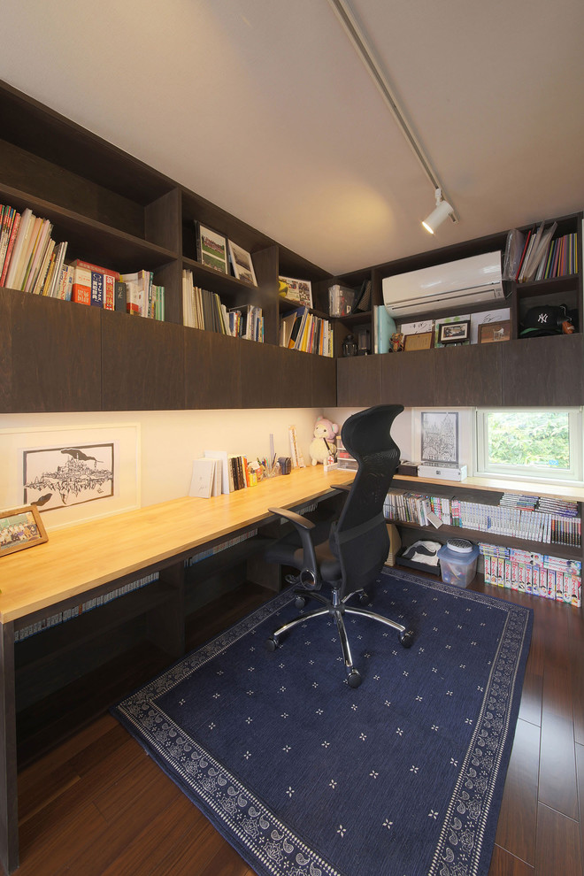 Foto de despacho minimalista grande sin chimenea con paredes marrones, suelo de contrachapado, escritorio empotrado y suelo marrón