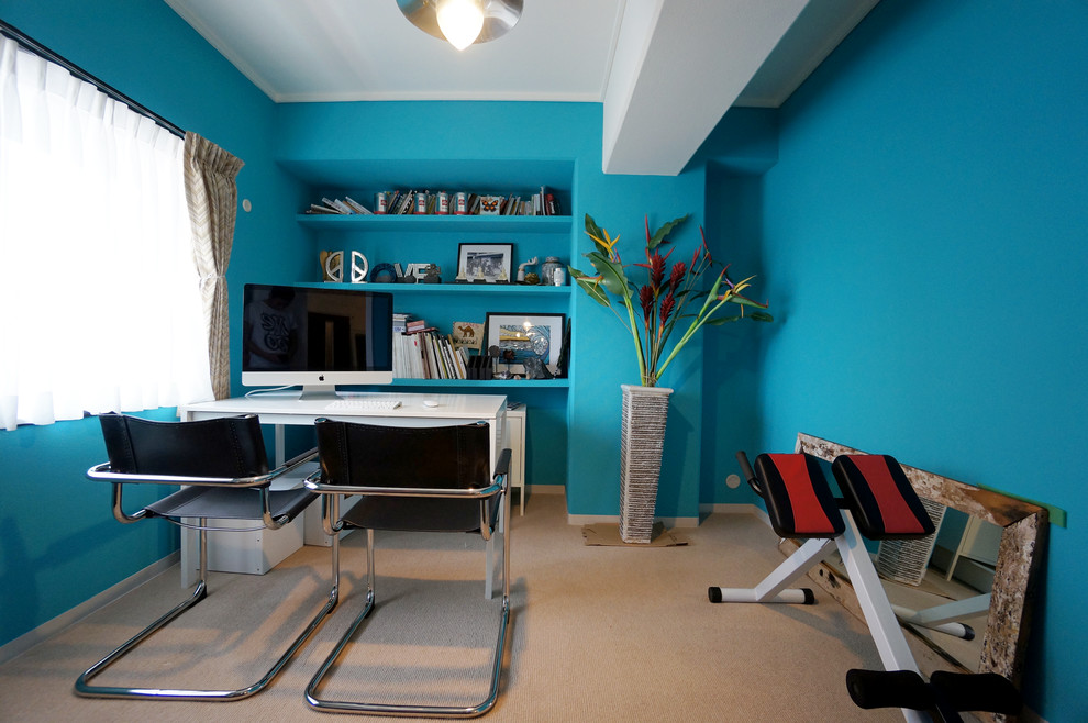 Idee per uno studio minimal con pareti blu, scrivania autoportante e nessun camino