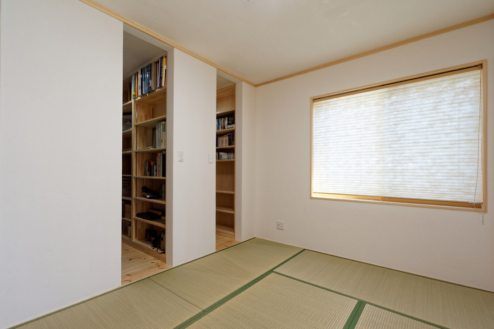 Ejemplo de despacho sin chimenea con biblioteca, paredes blancas, tatami, escritorio independiente y suelo beige