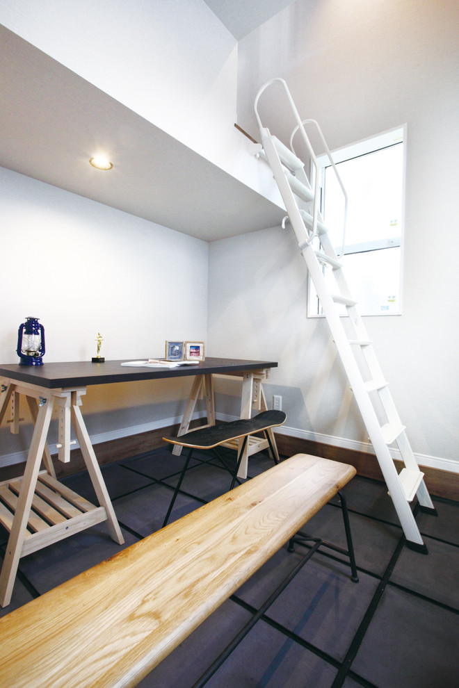 Foto de sala de manualidades moderna con paredes blancas, suelo de cemento, escritorio independiente y suelo gris