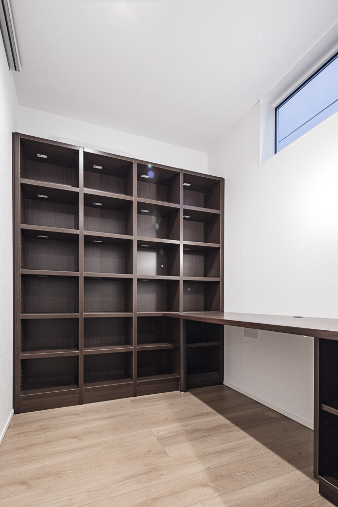 Ejemplo de despacho moderno sin chimenea con paredes marrones, suelo de contrachapado, escritorio empotrado y suelo marrón