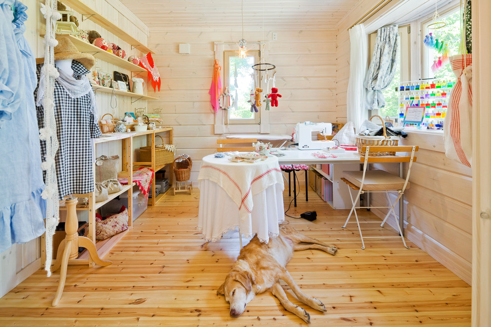 Skandinavisches Nähzimmer mit beiger Wandfarbe, hellem Holzboden und freistehendem Schreibtisch in Sonstige