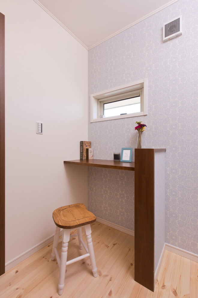 Ejemplo de despacho escandinavo con paredes grises, suelo de madera clara y escritorio empotrado
