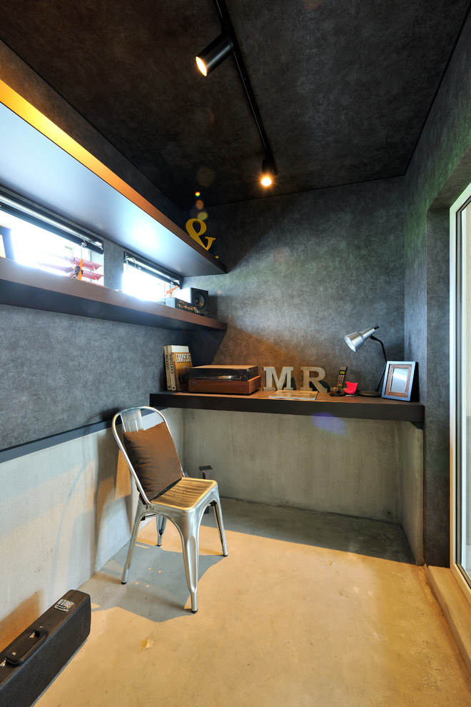 Foto de despacho urbano pequeño con paredes grises, suelo de cemento, escritorio empotrado y suelo gris