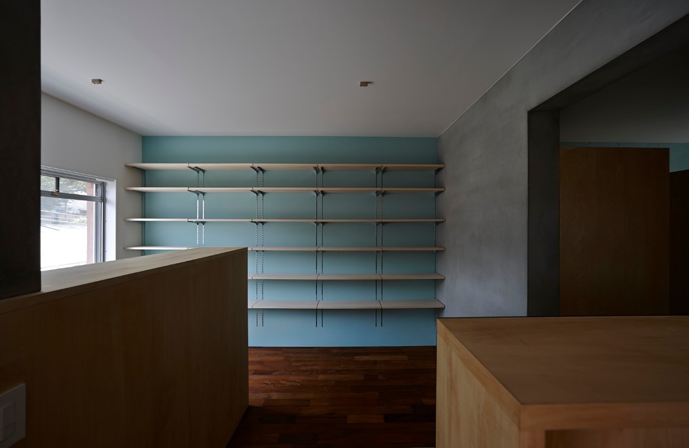 Inspiration pour un petit bureau nordique avec un mur bleu, parquet foncé, un bureau intégré et un sol marron.