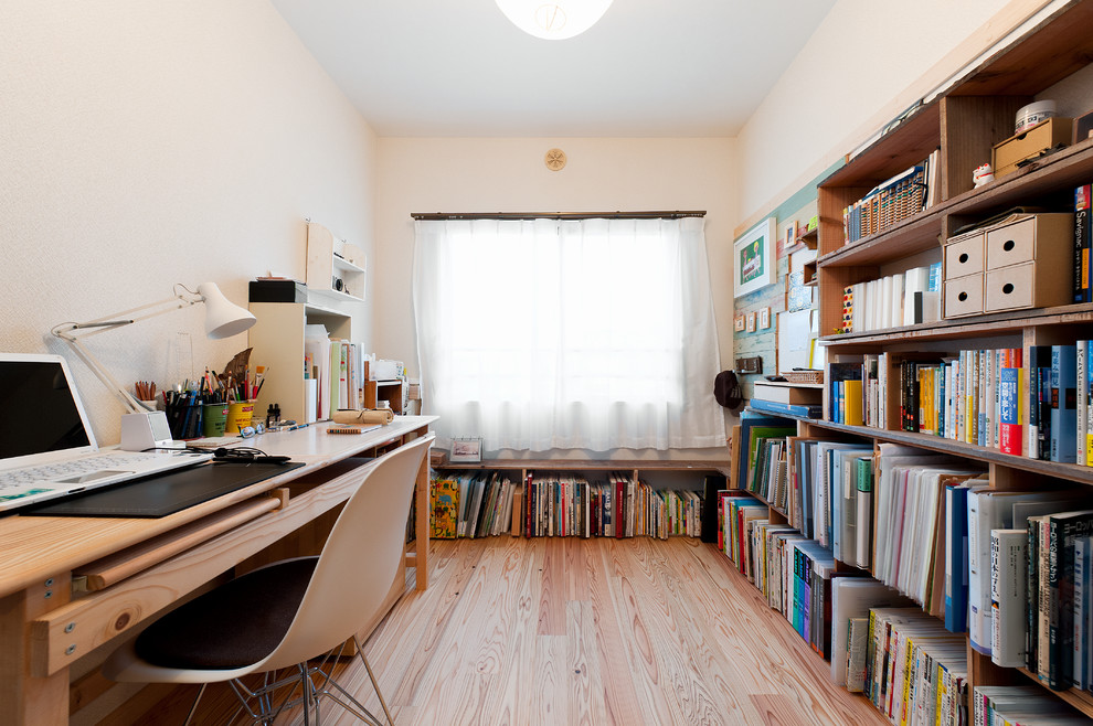 Idéer för minimalistiska hemmabibliotek, med vita väggar, ljust trägolv och ett fristående skrivbord