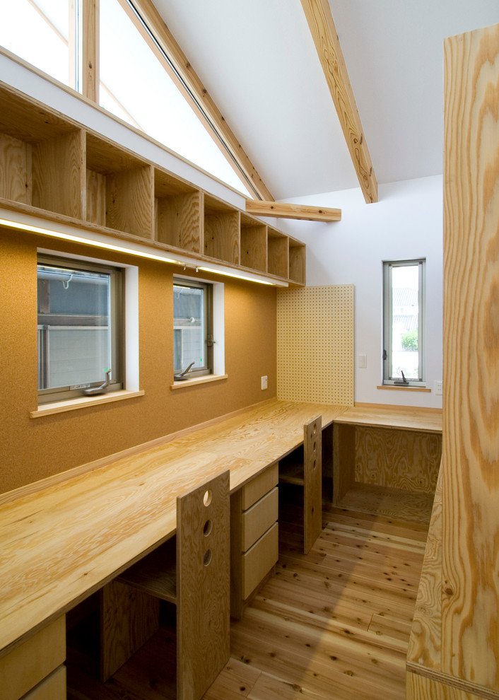 На фото: кабинет среднего размера в стиле модернизм с черными стенами, светлым паркетным полом, встроенным рабочим столом и бежевым полом с