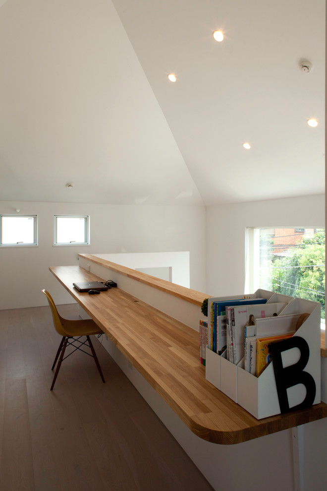 На фото: кабинет среднего размера в стиле модернизм с местом для рукоделия, белыми стенами, полом из фанеры, встроенным рабочим столом и бежевым полом с