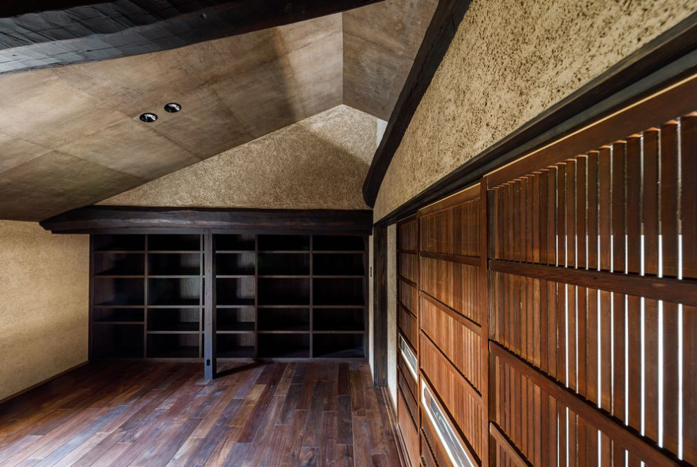Immagine di un grande studio chic con libreria, pareti beige, parquet scuro, pavimento marrone e travi a vista