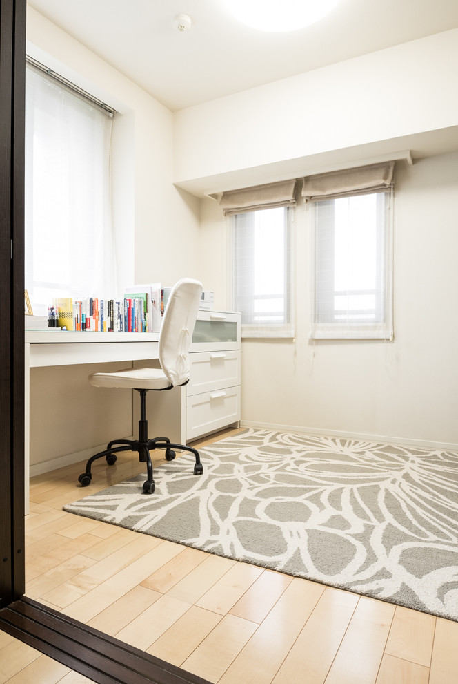 Ejemplo de despacho minimalista con paredes blancas, suelo de contrachapado, escritorio independiente y suelo beige