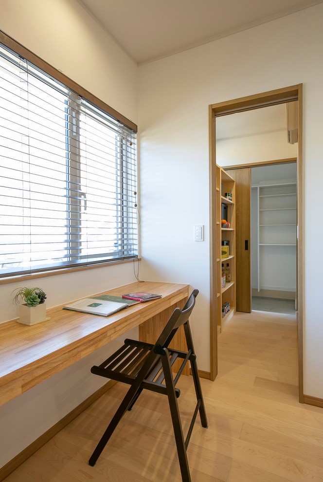 Идея дизайна: маленький кабинет в скандинавском стиле с белыми стенами, светлым паркетным полом, встроенным рабочим столом и бежевым полом для на участке и в саду