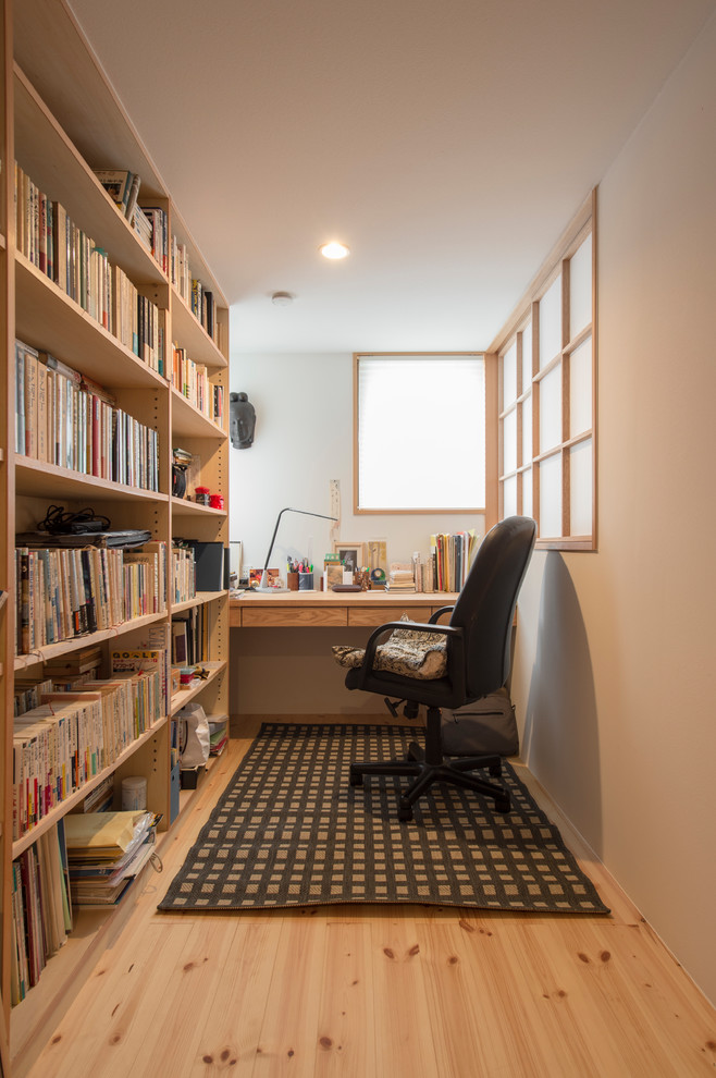 Inspiration för asiatiska arbetsrum, med vita väggar, ljust trägolv, ett fristående skrivbord och beiget golv