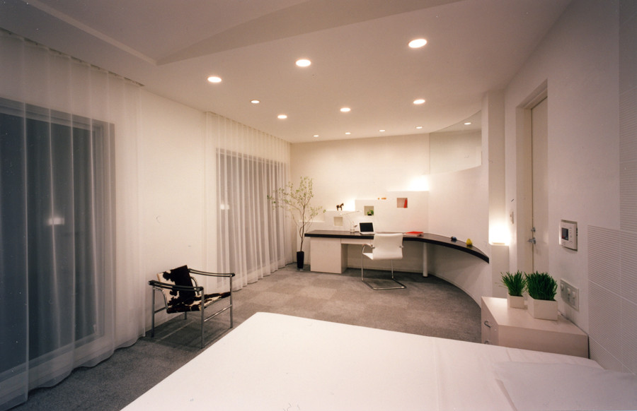 Réalisation d'un grand bureau minimaliste avec un mur blanc, moquette, un sol gris et un bureau intégré.